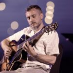 Enrick Adam performing jazz guitar in Doha, Qatar.